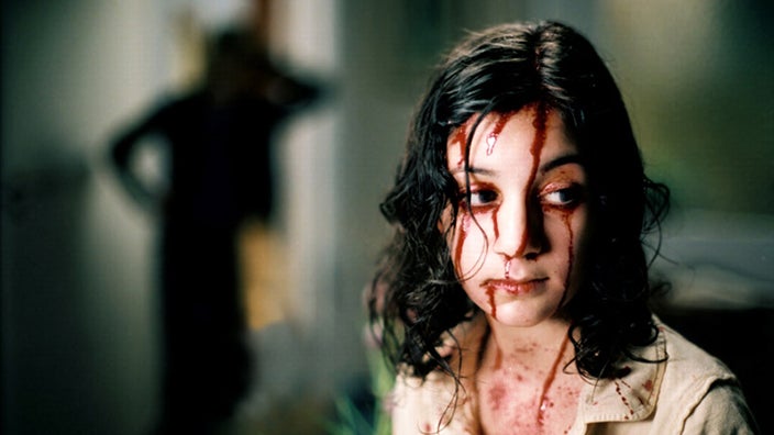 A young boy covered in blood