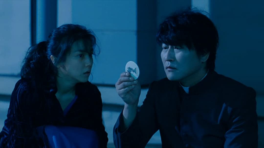 A man and woman look at a coin-shaped object