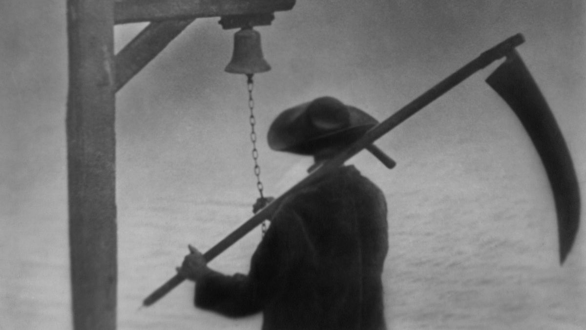 A man wields a scythe and rings a bell