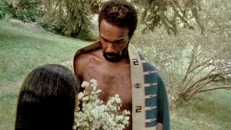 A man in a blanket with flowers in his hands