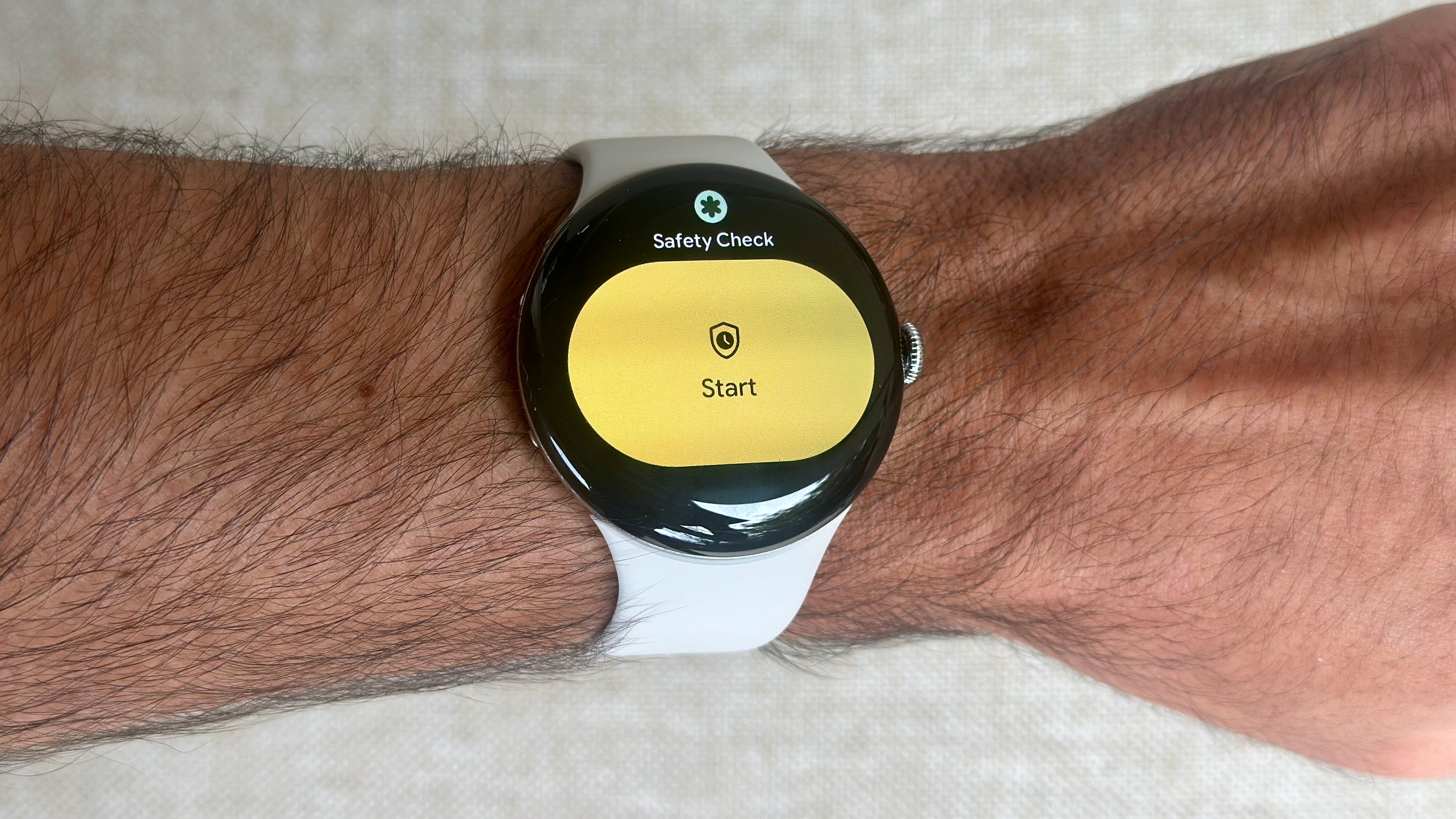 Μια φωτογραφία του Google Pixel Watch 4 που δείχνει το πλακίδιο ελέγχου ασφάλειας με ένα μεγάλο κίτρινο κουμπί Έναρξης.