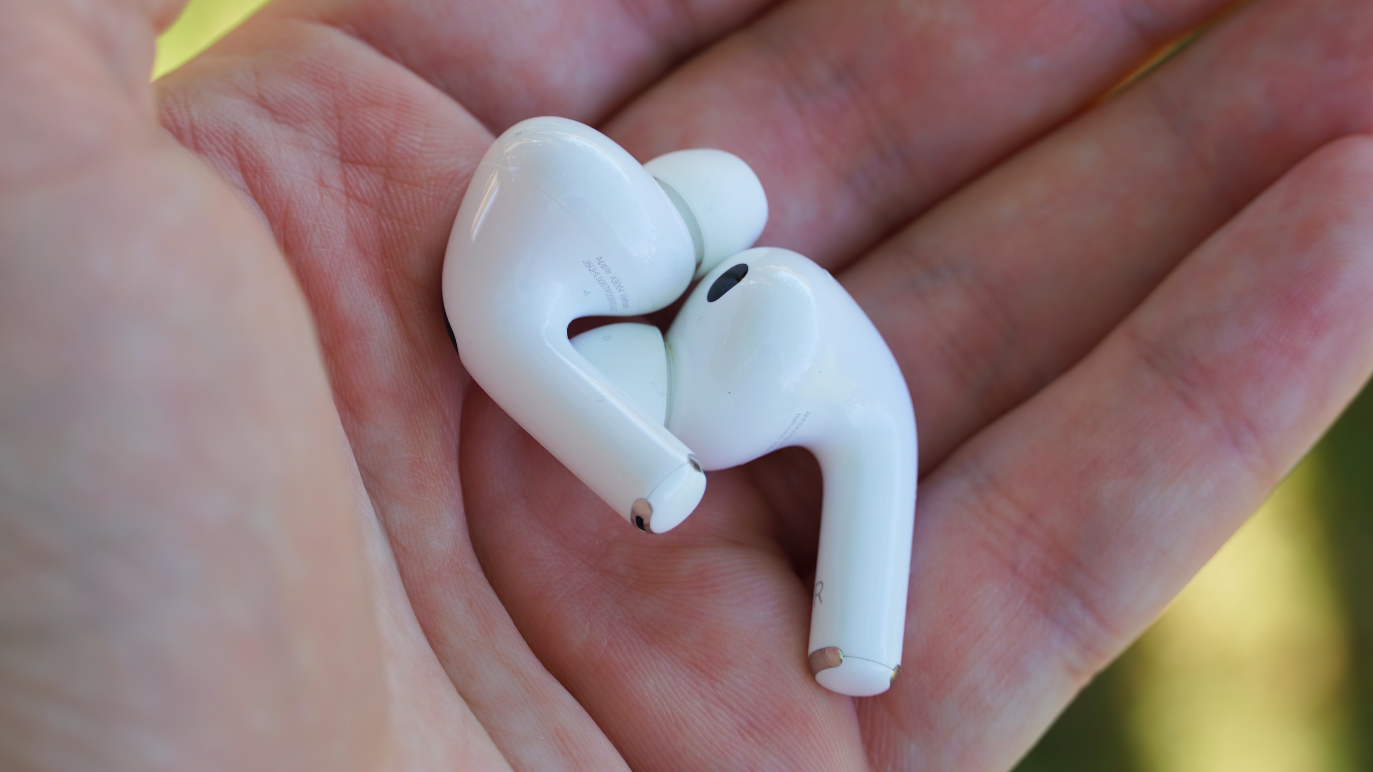 The AirPods Pro 3 with their charging case at a park.