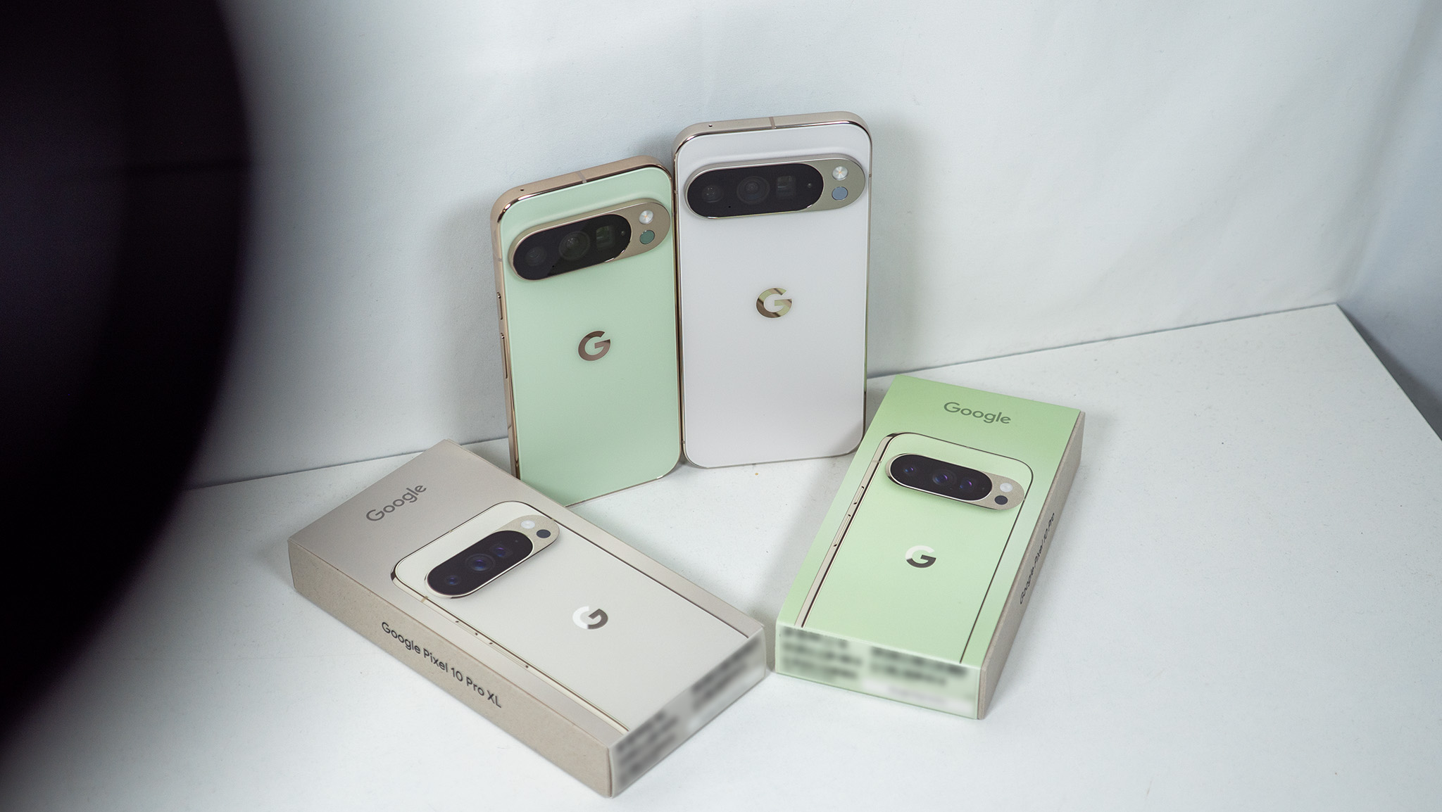 Ένα νεφρίτη Google Pixel 10 Pro και ένα λευκό Google Pixel 10 Pro XL με τα αντίστοιχα κουτιά τους