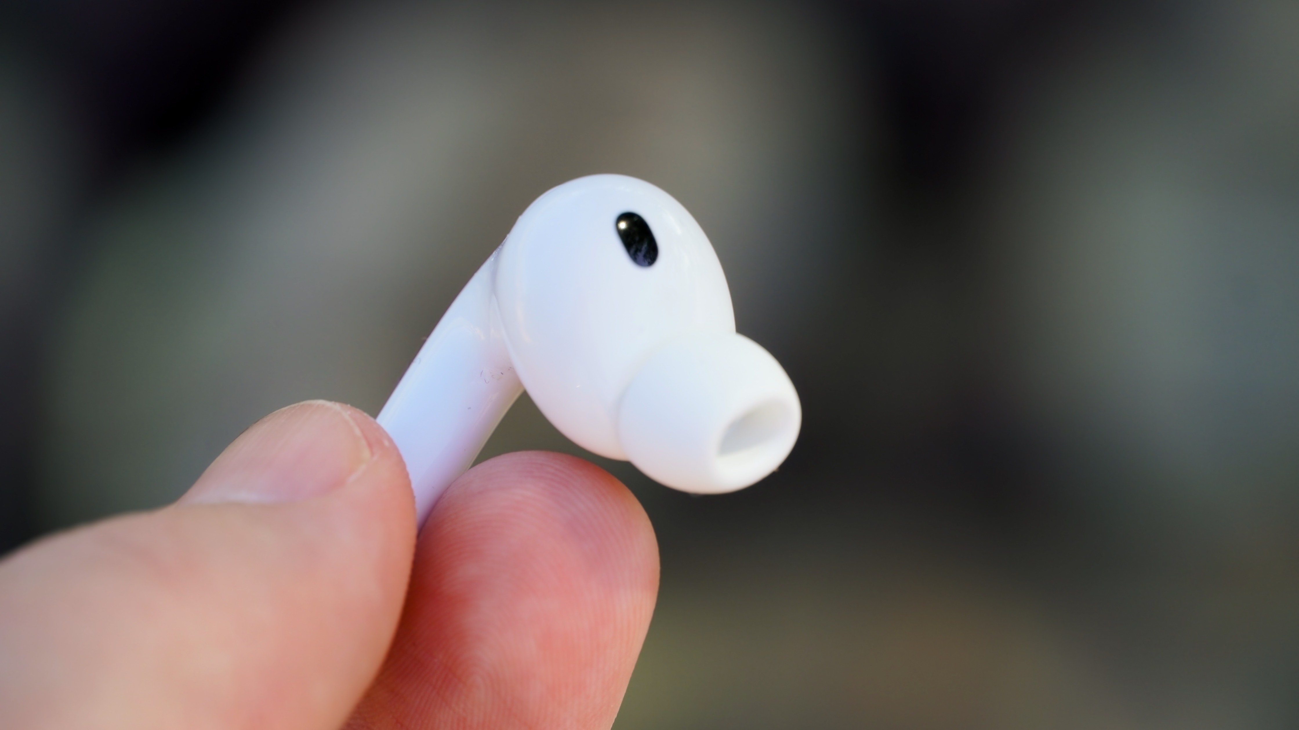 The AirPods Pro 3 with their charging case at a park.