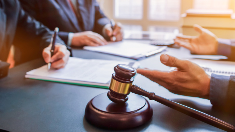 Δικαστής σφυρί στο τραπέζι μπροστά από επιχειρηματίες.