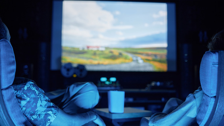 δύο άτομα που παρακολουθούν μια παράσταση σε έναν προβολέα