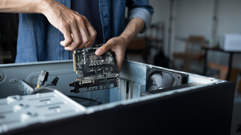 Ένα άτομο που εγκαθιστά ένα στοιχείο σε έναν επιτραπέζιο υπολογιστή.