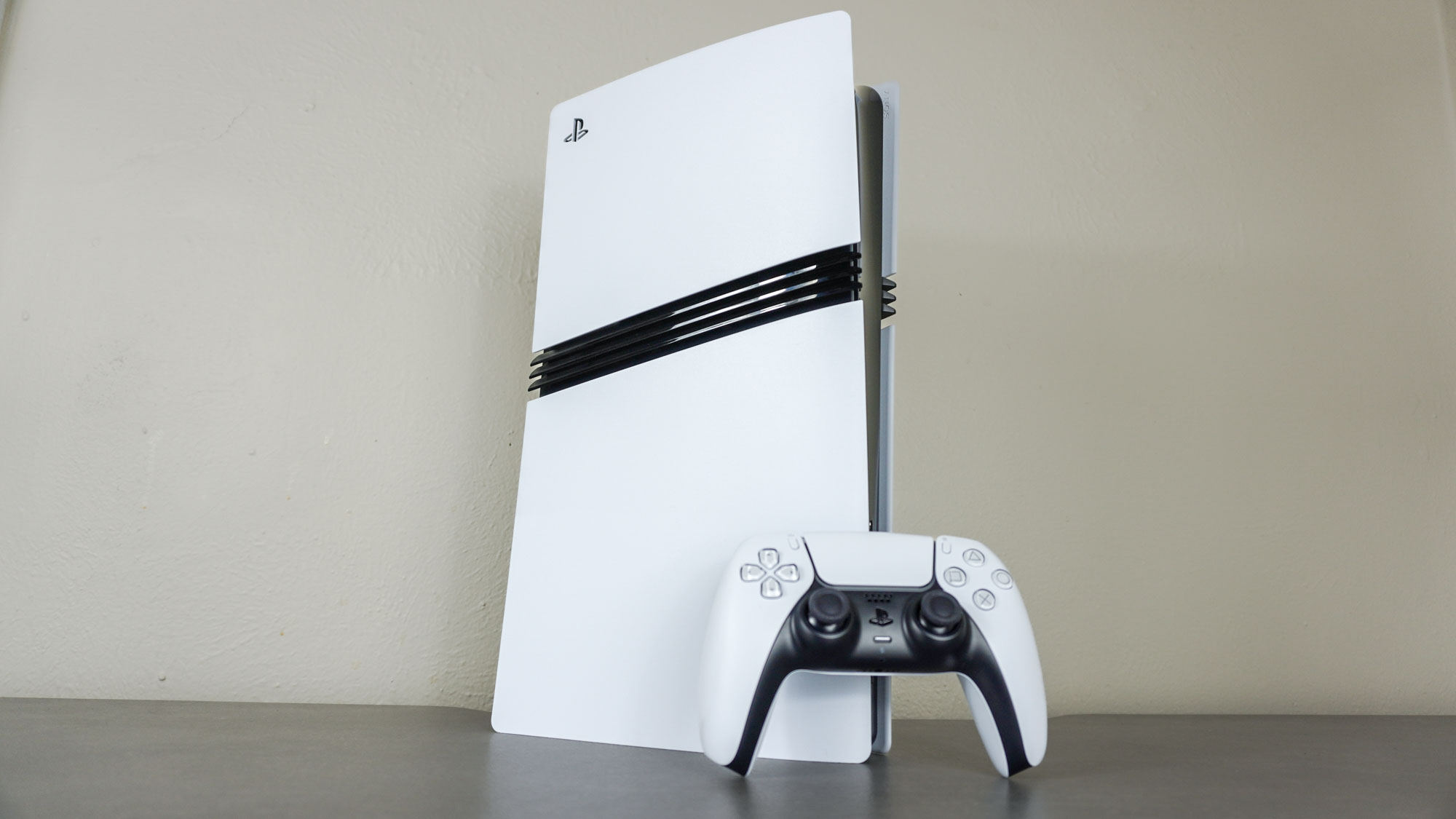 «Αγόρασες PS5; Αυτές είναι οι 7 μυστικές ρυθμίσεις που ΠΡΕΠΕΙ να αλλάξεις αμέσως!» Το PS5 Pro με ένα χειριστήριο DualSense σε ένα γραφείο