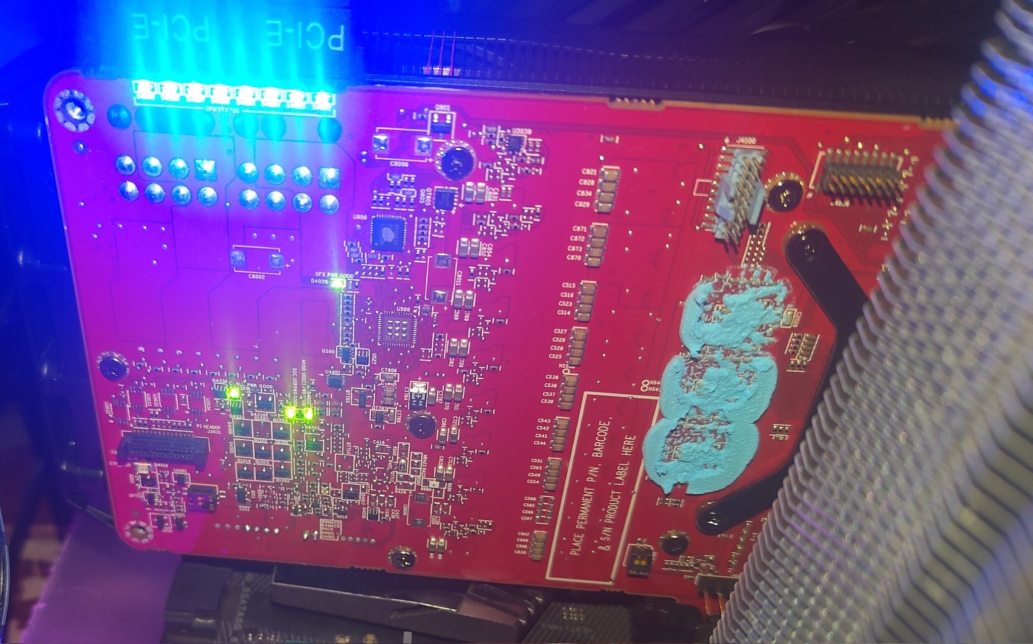 Η πίσω πλευρά μιας κάρτας γραφικών GFX PW6000 είναι ορατή, με μπλε θερμική πάστα που εφαρμόζεται κοντά στις υποδοχές και φωτιζόμενες θύρες PCIe.