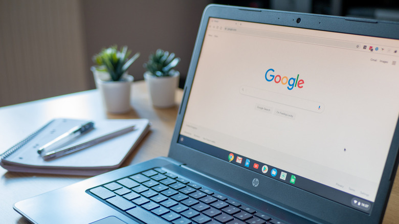 Το HP Chromebook άνοιξε στη σελίδα αναζήτησης Google δίπλα σε ένα χάρτινο σημειωματάριο και στυλό