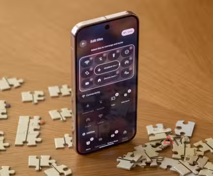 A Pixel 9 Pro open to quick settings, sitting upright among puzzle pieces.