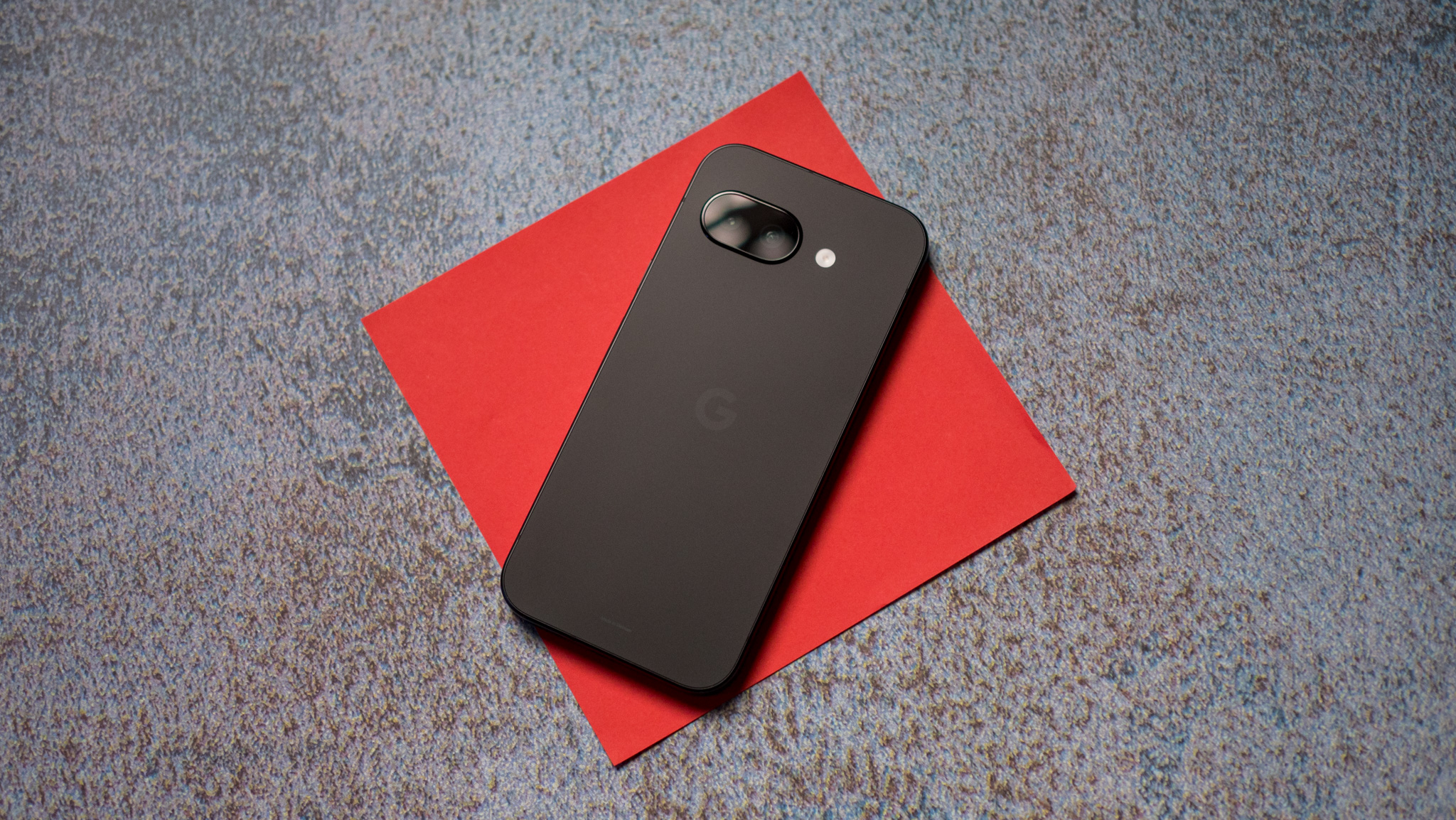 Google Pixel 9a back on a red background