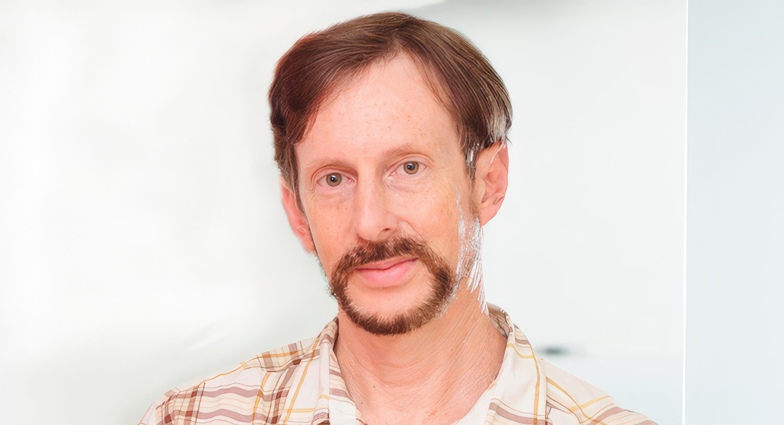 Is the MMO Genre Dead for Western AAA Developers? We Asked Three Industry Veterans A person with short brown hair and a beard wearing a plaid shirt against a plain background.