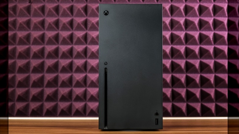 Το Xbox Series X εμφανίζεται σε ένα κόκκινο φόντο με μαξιλαράκια.