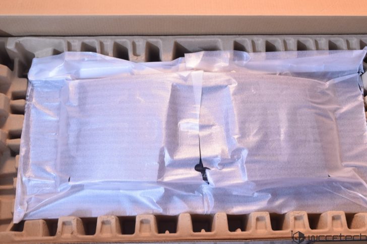 A packed electronic component wrapped in protective material inside a cardboard box, with wccftech branding visible in the corner.