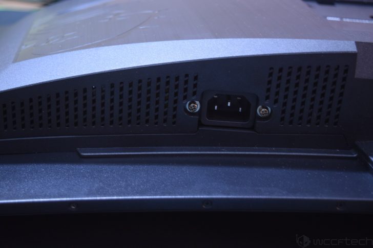 A close-up of the rear panel of an unbranded electronic device with a visible power input socket surrounded by ventilation grills.