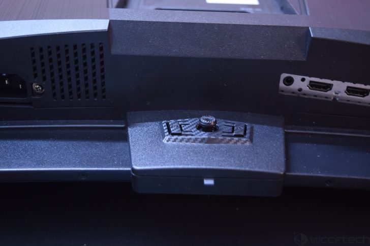 The back panel of an unbranded monitor features a textured stand adjustment knob and HDMI ports.