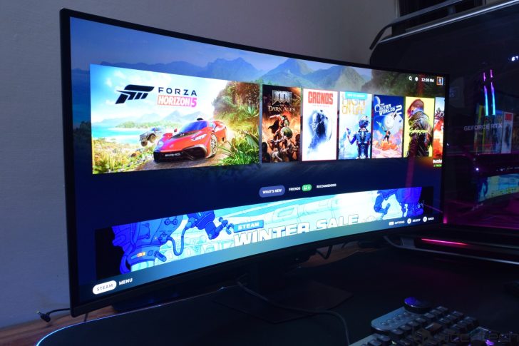 A curved monitor displays the Steam interface showcasing games like 'Forza Horizon 5,' 'DOOM: The Dark Ages,' 'Crions,' and 'The Outer Worlds 2,' with a 'Winter Sale' banner visible.