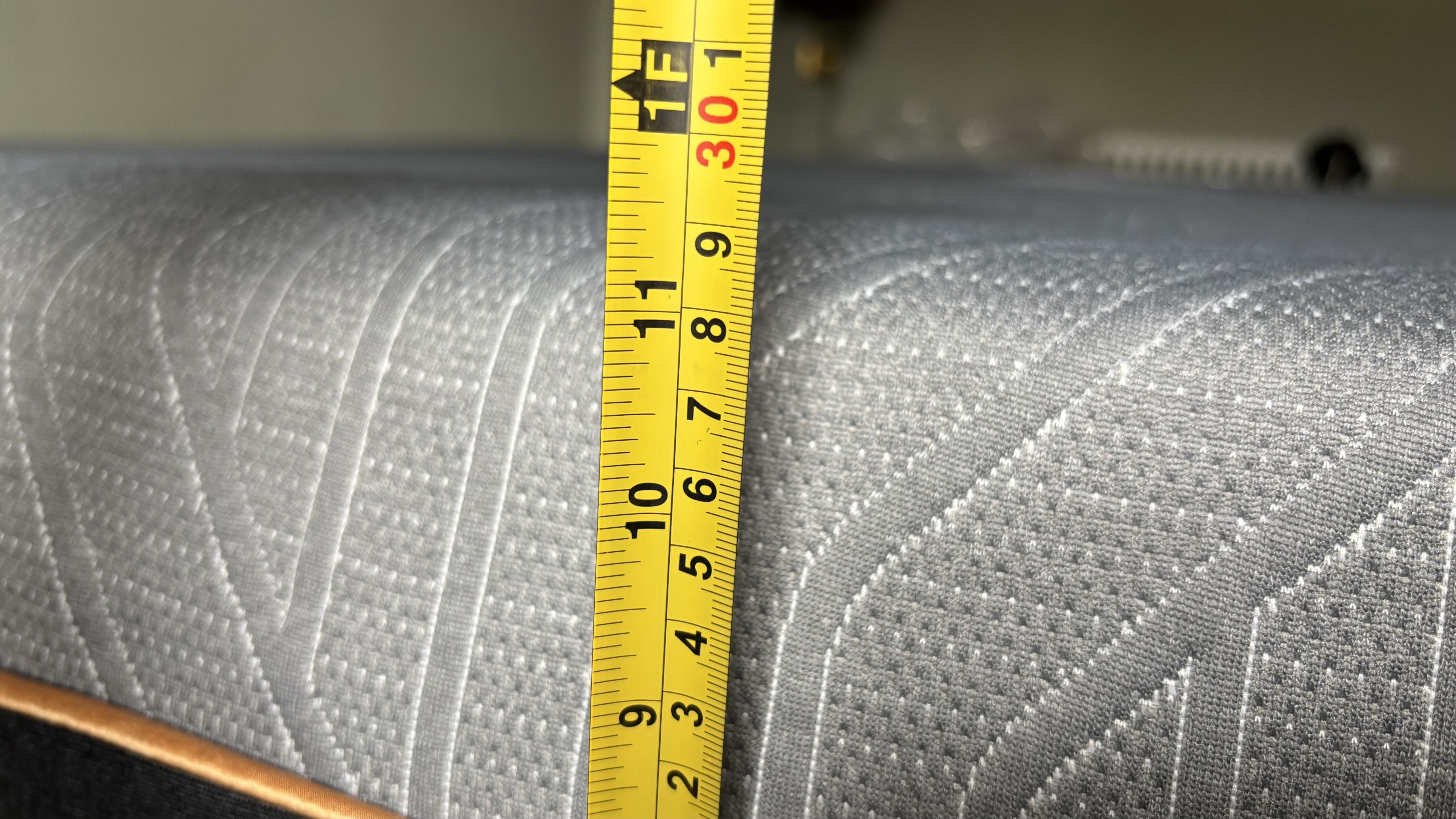 Μια μεζούρα μετρά το ύψος ενός νέου EGOHOME Black 12" Στρώμα.