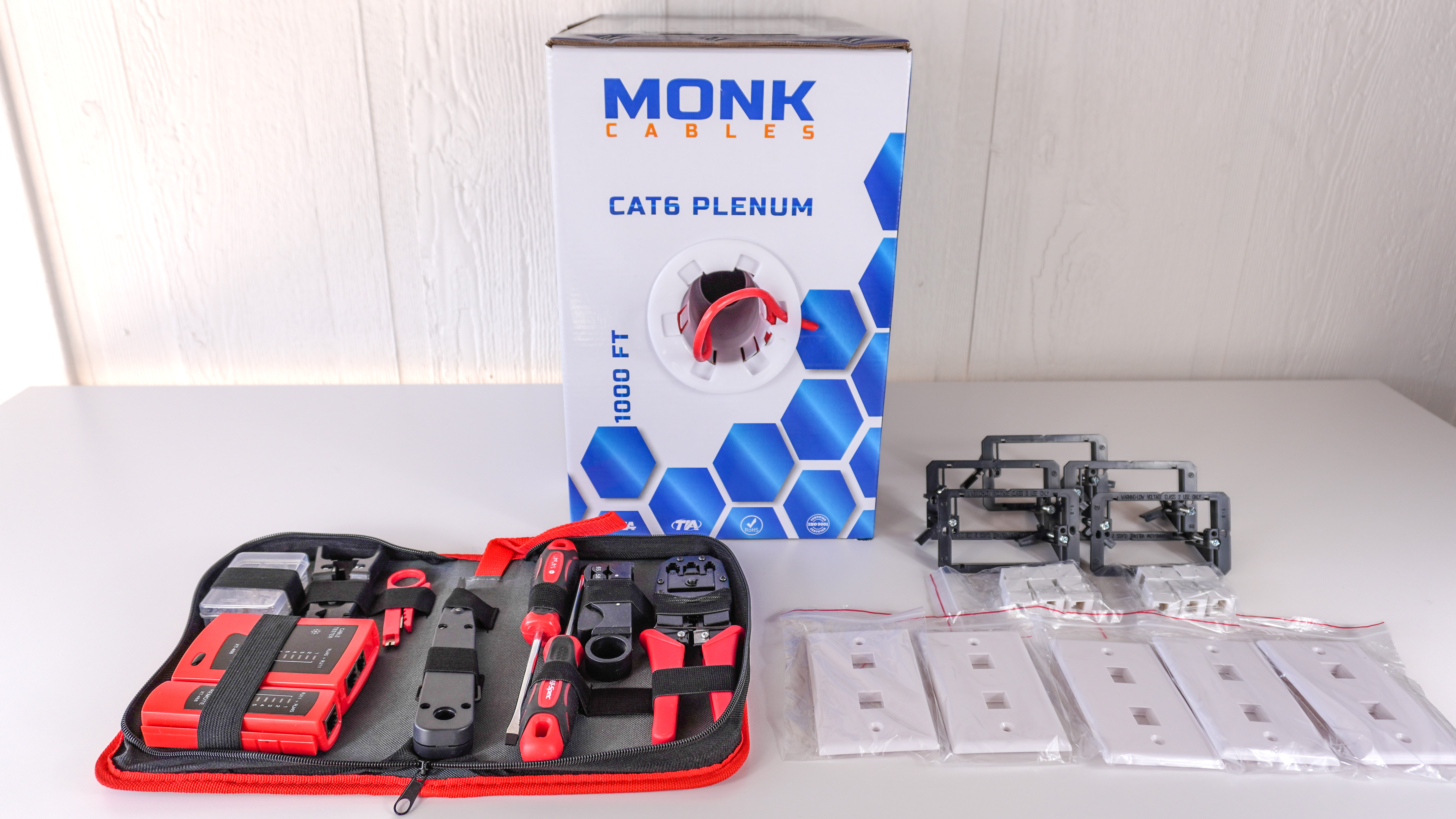 Όλα τα εργαλεία και οι προμήθειες που χρειάζονται για την καλωδίωση ενός σπιτιού για Ethernet απλωμένα σε ένα τραπέζι