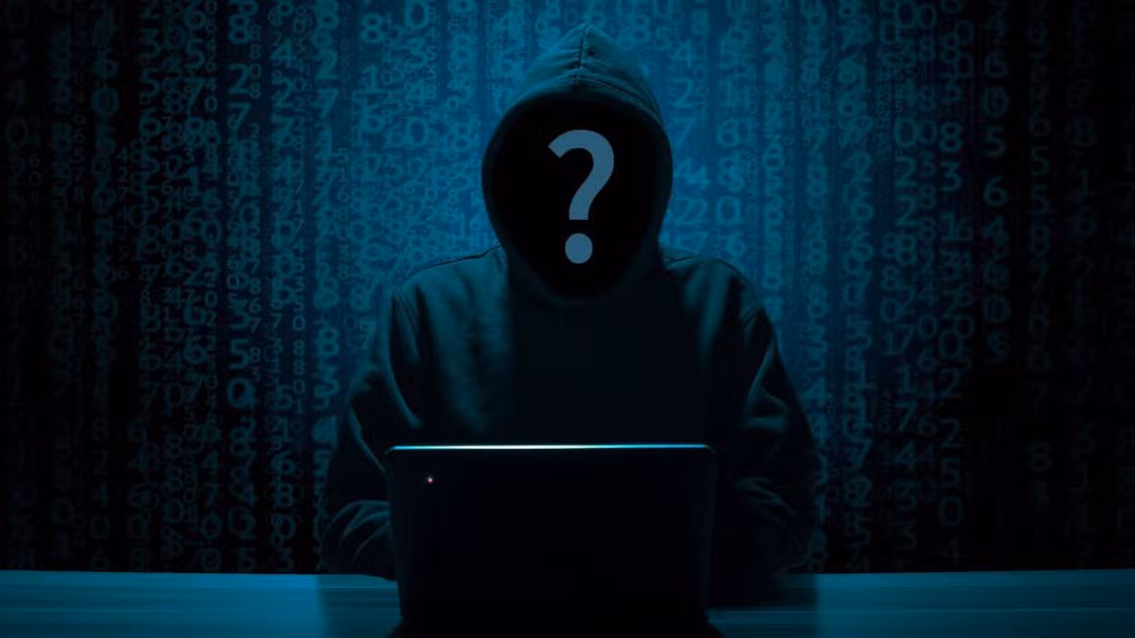 Χάκερ σε έναν υπολογιστή σε ένα σκοτεινό δωμάτιο.