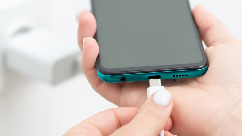 Άτομο που συνδέει το καλώδιο φόρτισης στο τηλέφωνο