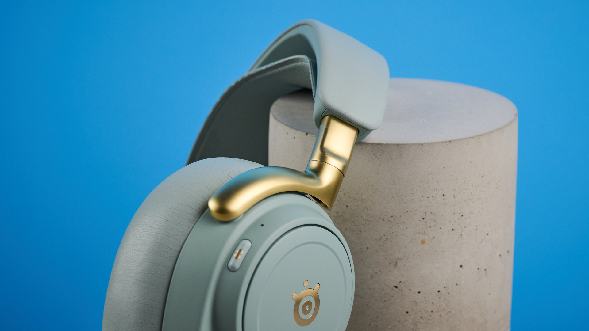The SteelSeries Arctis Nova Elite leaning on a stone plinth with a blue background