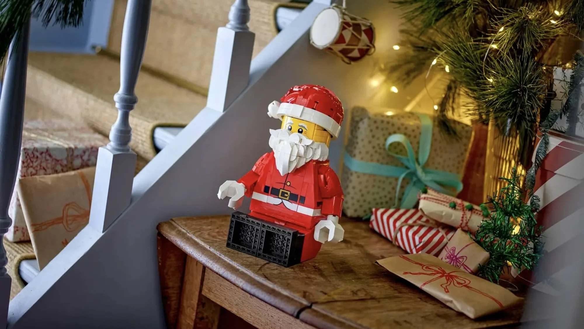 Lego Up-Scaled Santa Minifigure on side table next to other holiday decor