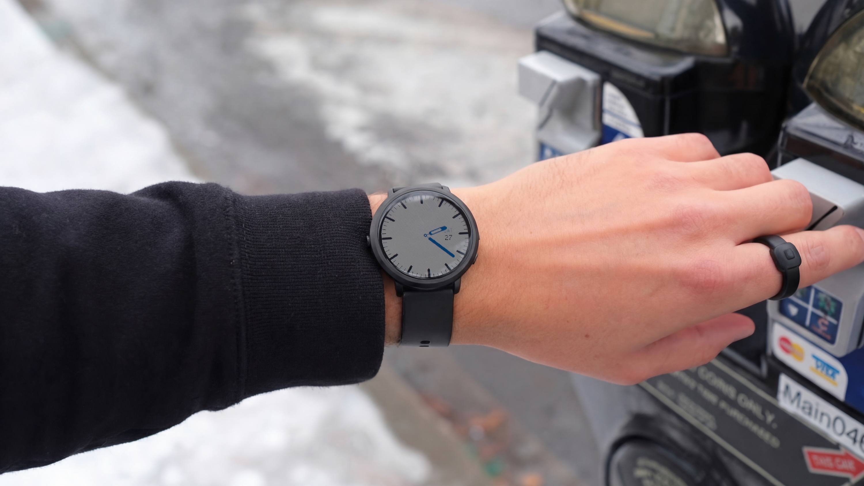 Φωτογραφία του έξυπνου ρολογιού Pebble Round 2 και του έξυπνου δαχτυλιδιού Index 1 που φοριέται έξω και φαίνεται το χιόνι.