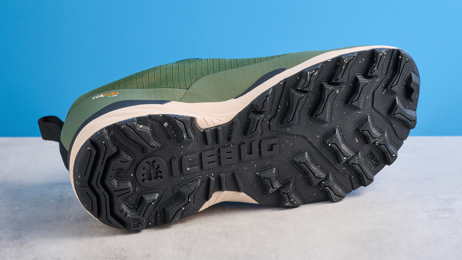 Icebug Rover 2 RB9X GTX σε ανοιχτόχρωμο/μαύρο χρώμα φωτογραφημένο μπροστά σε μπλε φόντο.