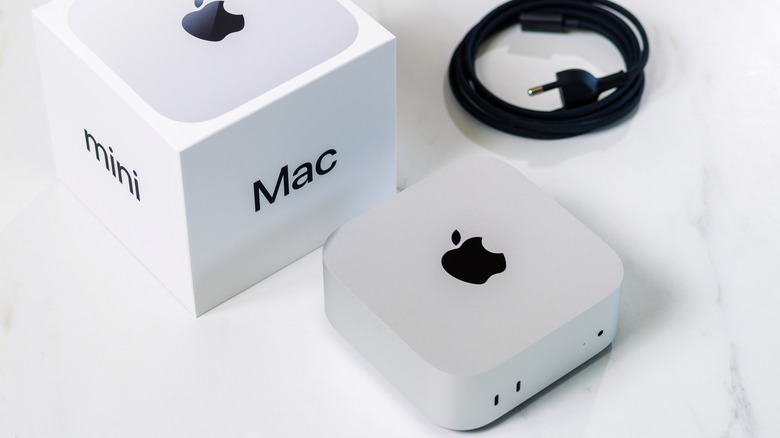 Apple Mac mini στο τραπέζι με κουτί και αξεσουάρ