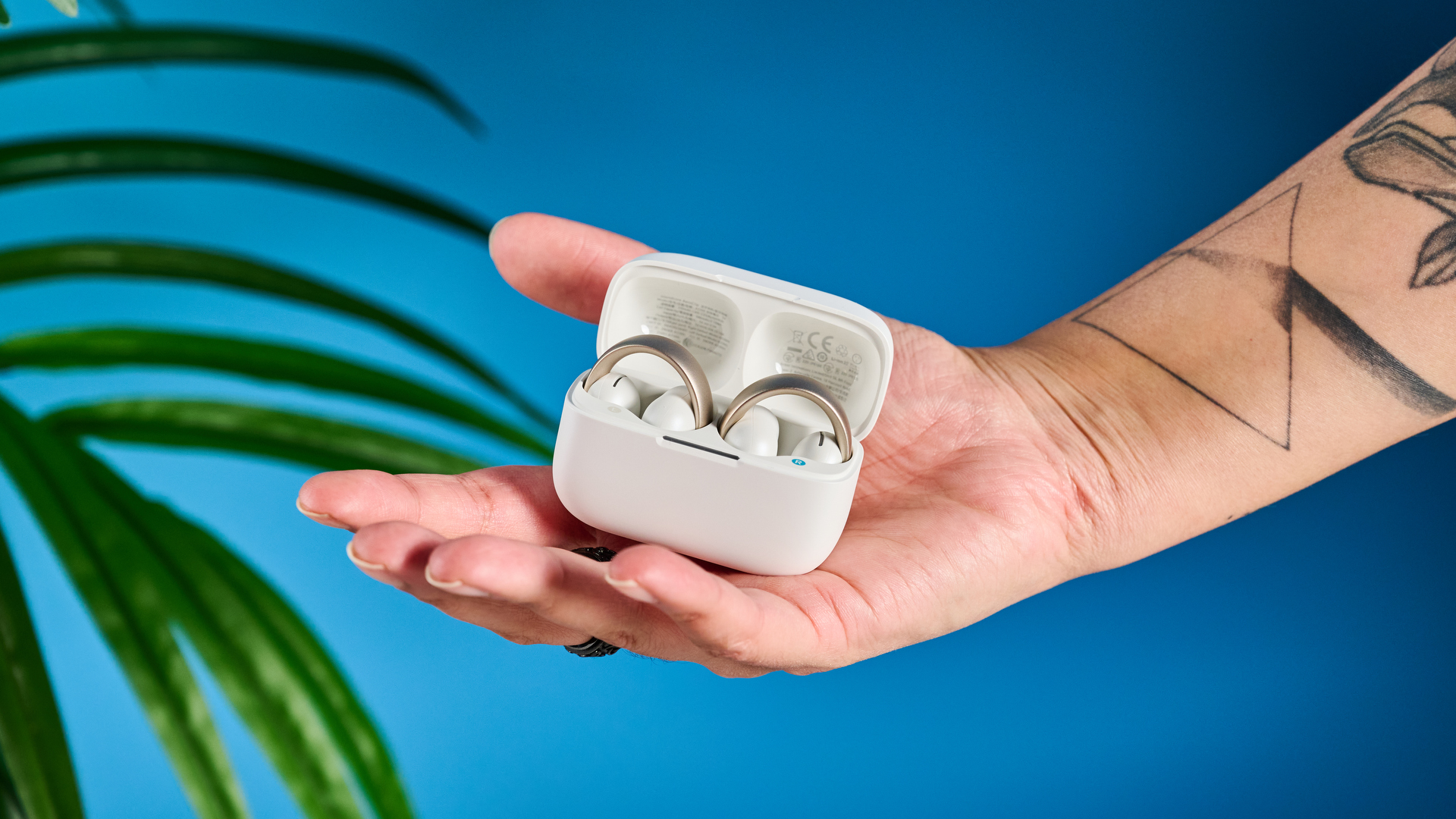 Soundcore AeroClip ακουστικά ανοιχτού αυτιού σε ομίχλη σαμπάνιας σε μπλε φόντο