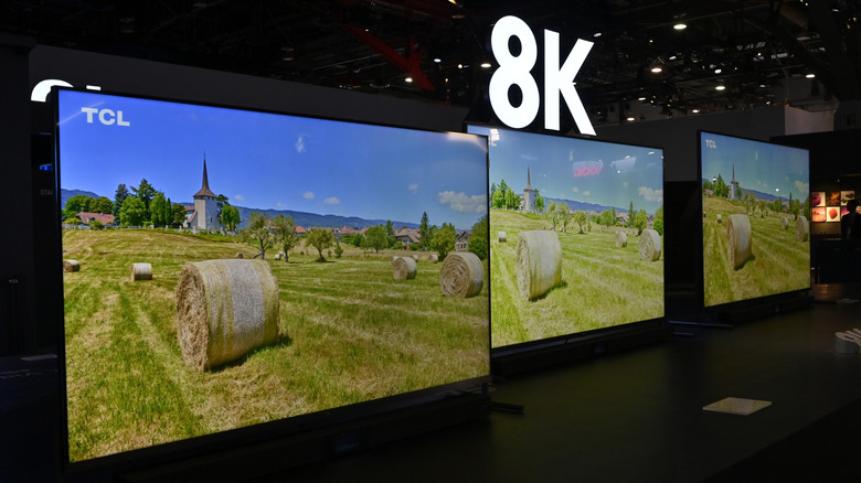 Το TCL 8K εμφανίζεται σε μια γραμμή σε μια παράσταση με ένα σύμβολο 8K από πάνω τους. Οι τηλεοράσεις δείχνουν μπάλες σανού σε ένα χωράφι.
