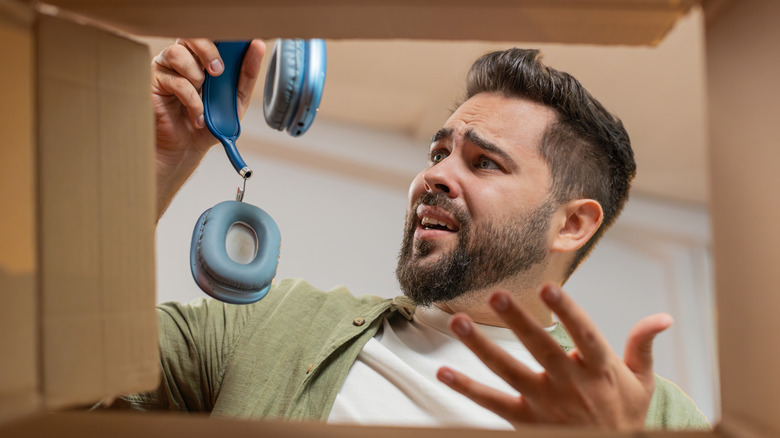 Απογοητευμένος άνδρας που κρατά ακουστικά