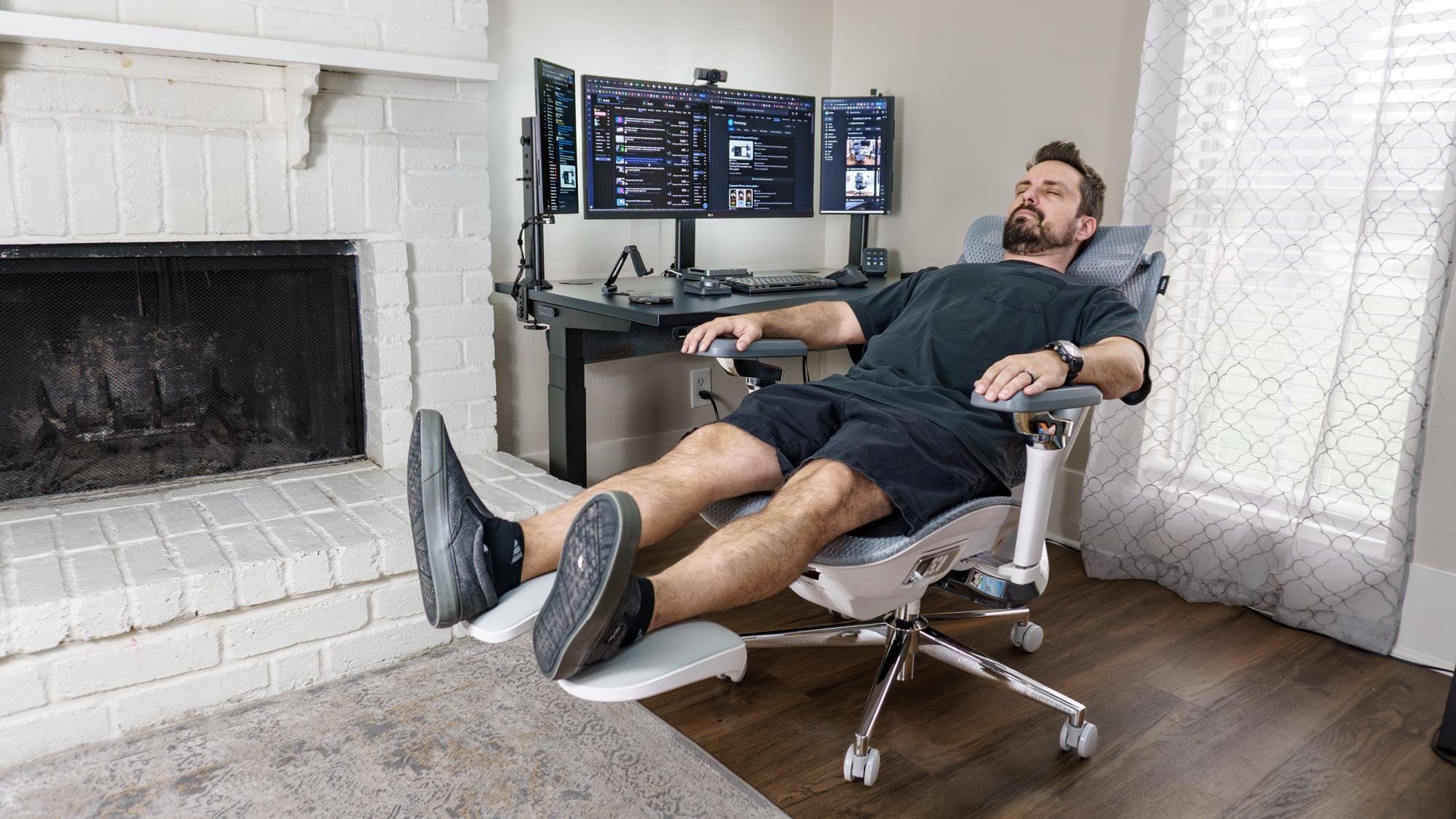 A person reclining in the Hbada X7 office chair in front of their desk