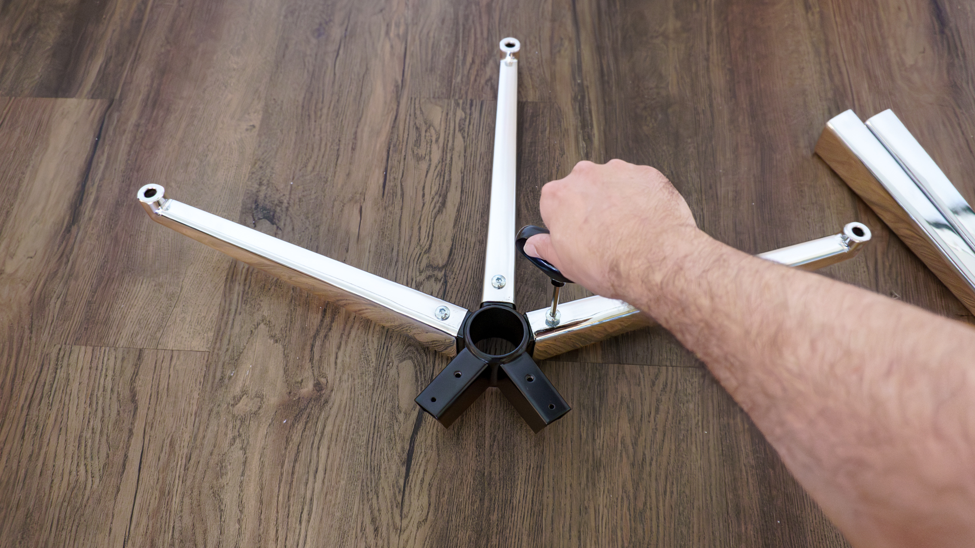 A person assembling the base of the Hbada X7 office chair