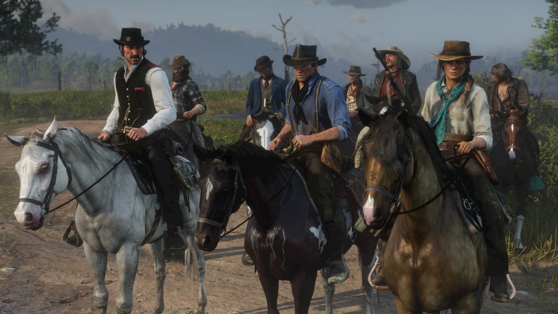 A group of characters on horseback in Red Dead Redemption 2 riding through a rural landscape.