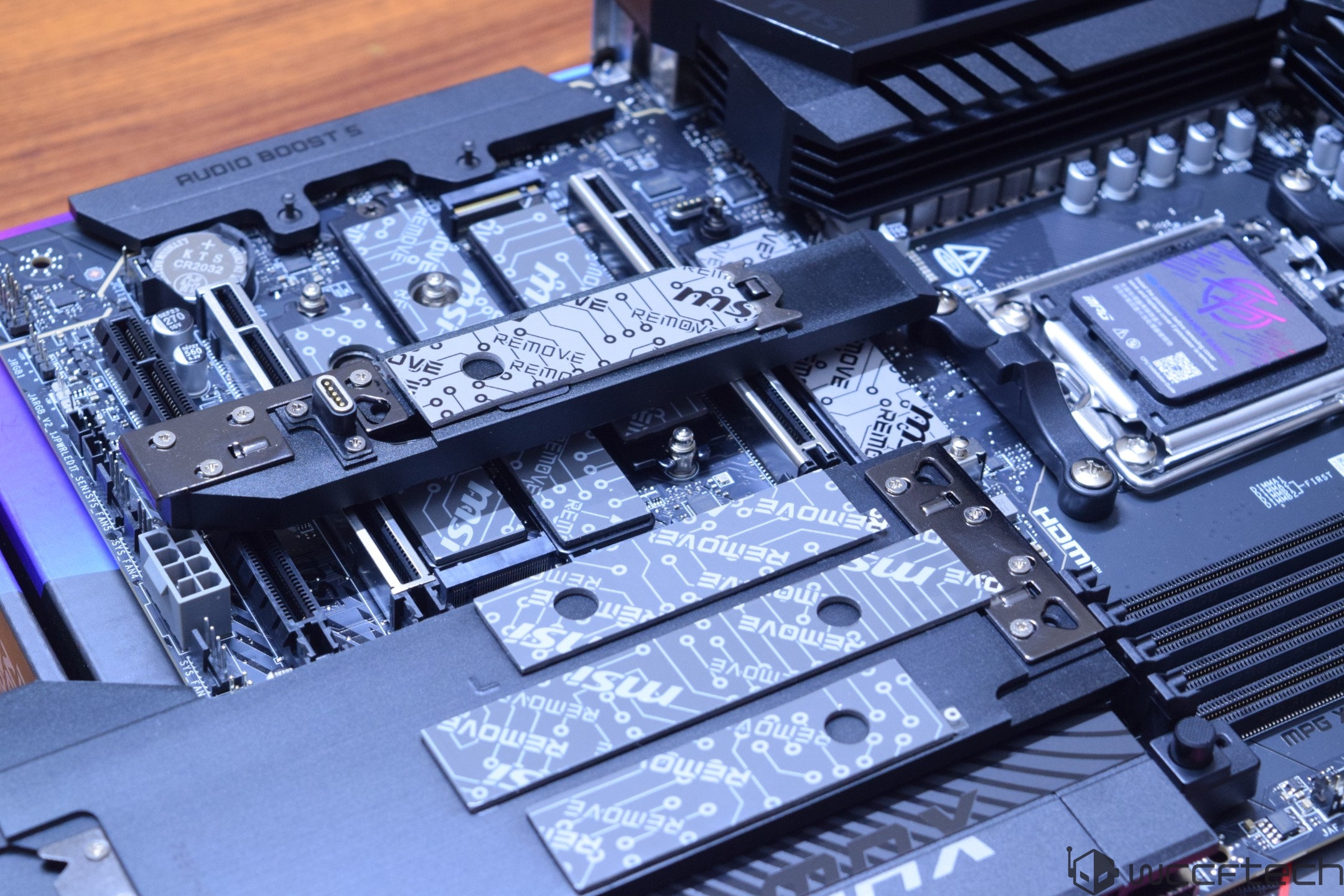 Κοντινό πλάνο μιας μητρικής πλακέτας ASUS που διαθέτει κάρτα MSI Gen5 M.2 και 'AUDIO BOOST 5' στην ψύκτρα.