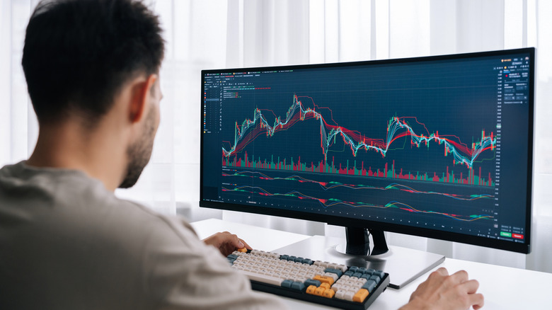 Ανδρας σε γραφείο χρησιμοποιώντας υπολογιστή με υπερ-ευρεία οθόνη