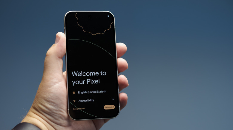 Κοντινό πλάνο ενός ατόμου που κρατά το Pixel 9 με τον οδηγό εγκατάστασης του στην οθόνη