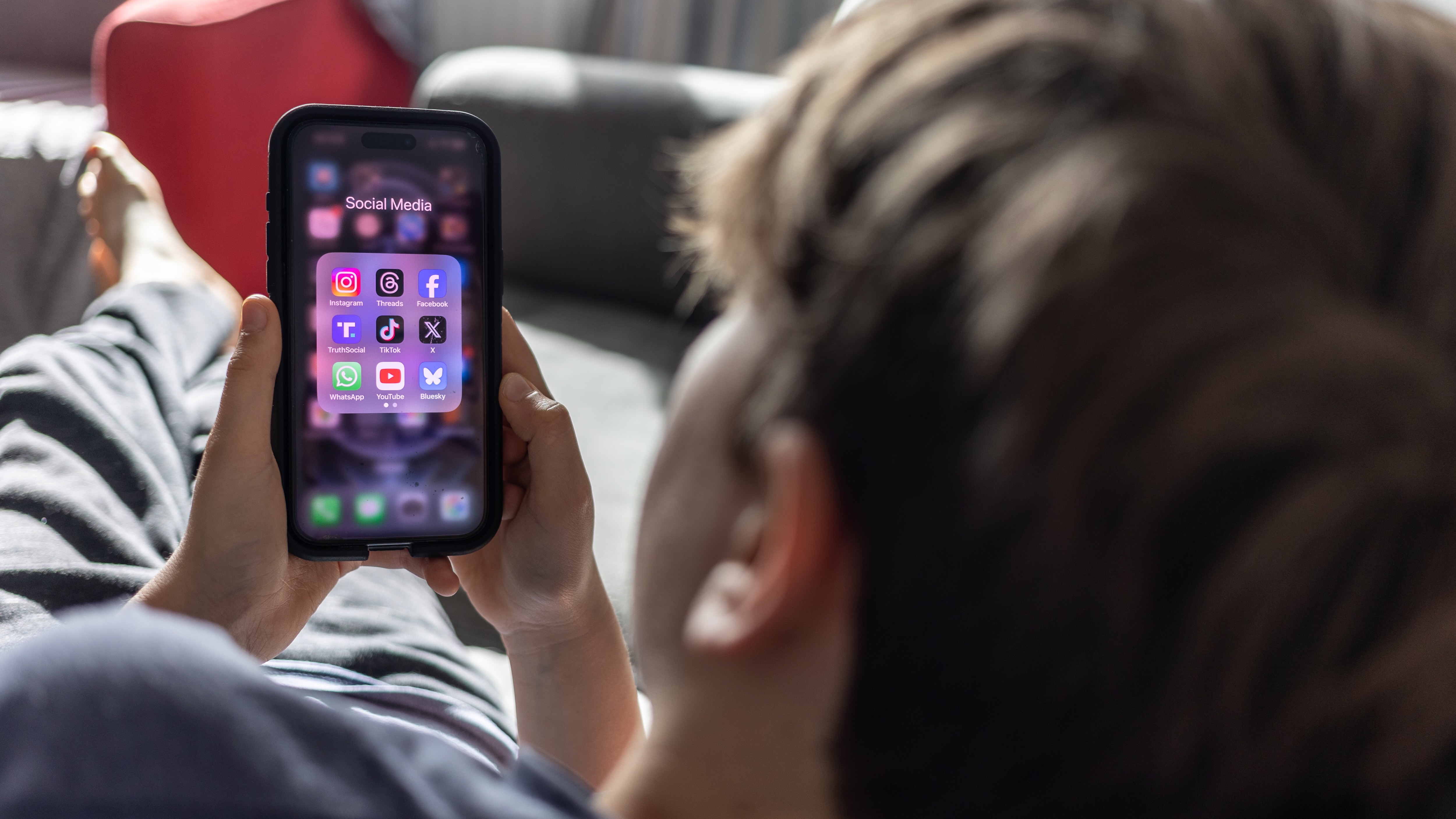 Έφηβος που κοιτάζει τα κοινωνικά μέσα σε ένα κινητό τηλέφωνο