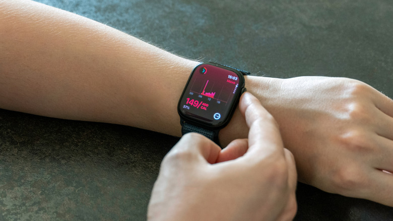 Ένα αντρικό χέρι που αγγίζει το Digital Crown σε ένα Apple Watch.