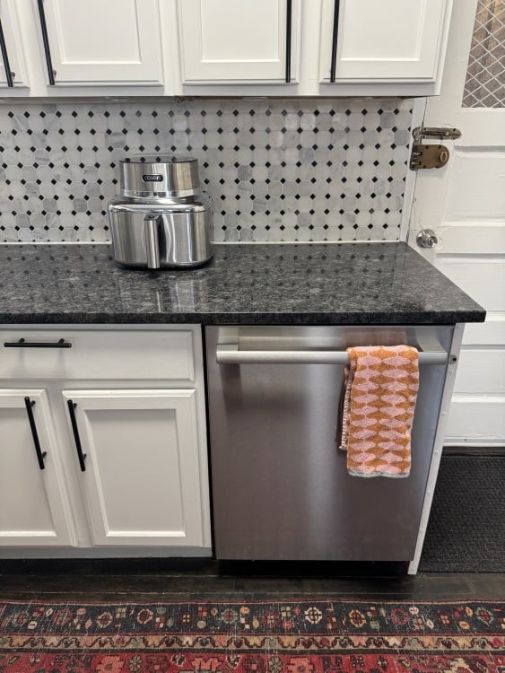 μια εικονική φριτέζα αέρα cosori σε έναν πάγκο κουζίνας κοντά σε ένα πλυντήριο πιάτων bosch