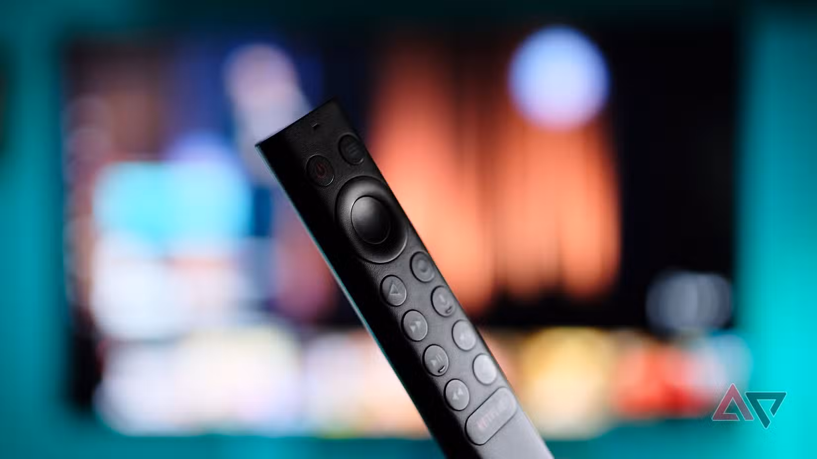 κινηματογράφηση σε πρώτο πλάνο ενός μαύρου τηλεχειριστηρίου smart τηλεόρασης με τηλεόραση στο παρασκήνιο