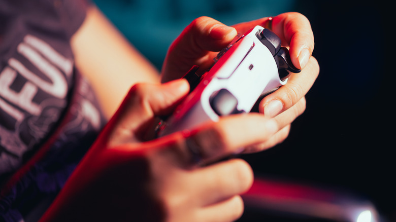 Κοντινό πλάνο των χεριών χρησιμοποιώντας το χειριστήριο PlayStation 5 DualSense