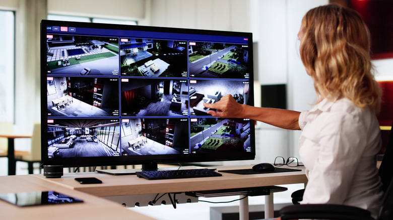 Γυναίκα στο γραφείο παρακολουθεί πλάνα από κάμερα ασφαλείας στο σπίτι