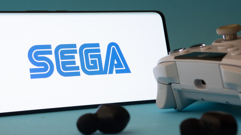 Smartphone με λογότυπο Sega δίπλα στο χειριστήριο παιχνιδιών