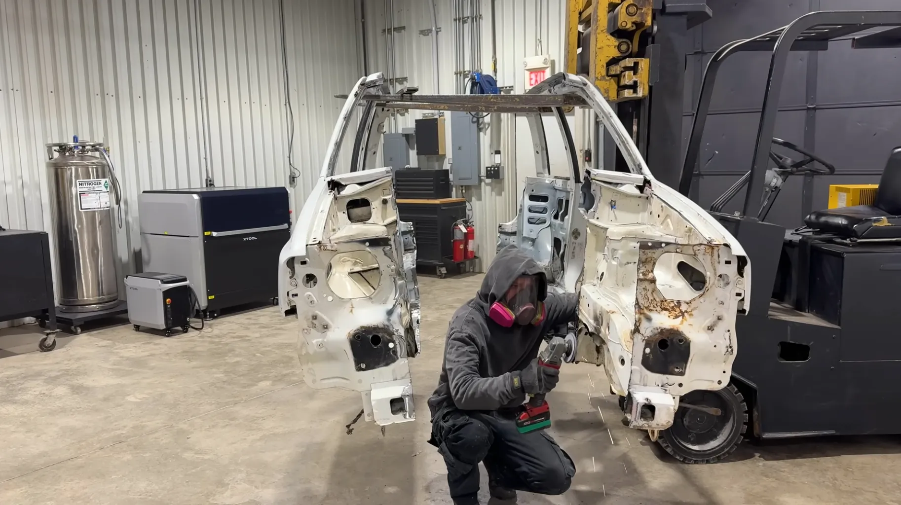 ένας άντρας που φοράει μάσκα αερίου ανάμεσα σε ένα αυτοκίνητο που είναι χωρισμένο στη μέση