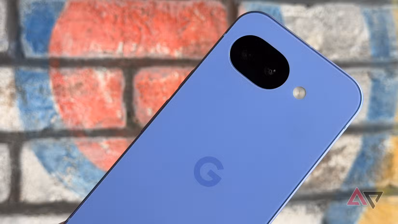 Google Pixel 10a in Lavender held against a wall