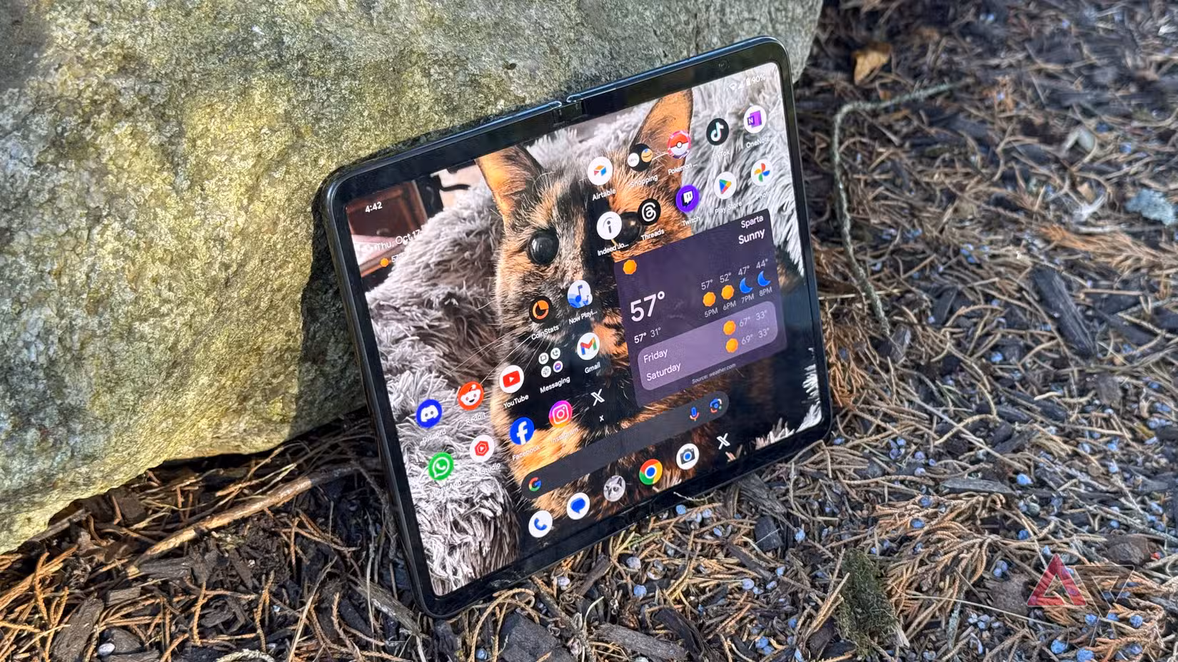 Το Google Pixel Fold ξαπλώνει σε έναν βράχο σε εξωτερικούς χώρους